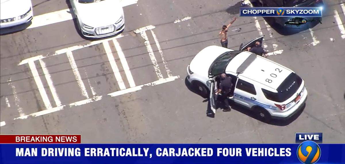 In this image from WSOC’s helicopter, a man surrenders to Charlotte-Mecklenburg police officers at the intersection of South and East boulevards after a wreck ended an hours-long pursuit across the area on Thursday, July 7, 2022. The suspect was later identified as Tyler Harding of Texas.