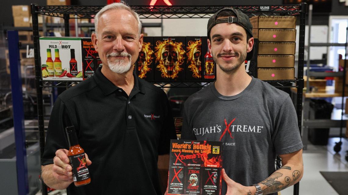 Bret Morey, left, and his son, Elijah, display bottles of their hot sauce brand, Elijah’s Xtreme, inside their warehouse in Gastonia. The Moreys began their hot sauce company at their home, in the garage, and generated $5 million in revenue in 2023.