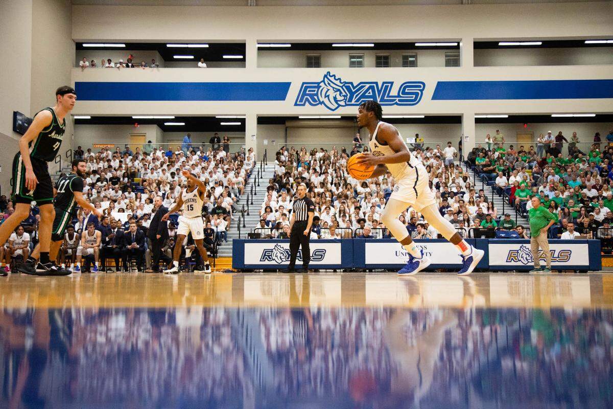 AJ McKee brings the ball up the court against Marshall in Queens’ first home men’s basketball game as a Division I program — on Nov. 7, 2022, in the Levine Center.