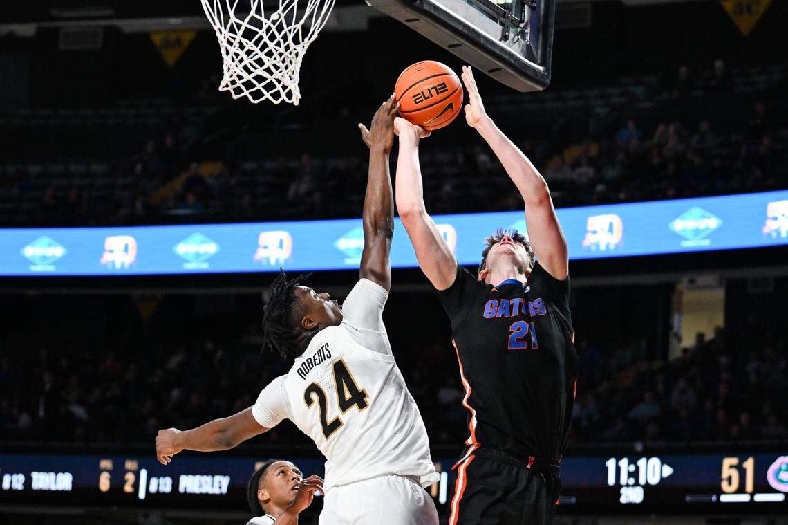 Alex Condon of the Florida Gators drives the ball to the basket against JaQualon Roberts (24) of the Vanderbilt Commodores during a 2024 game. Roberts has transferred to Davidson. 