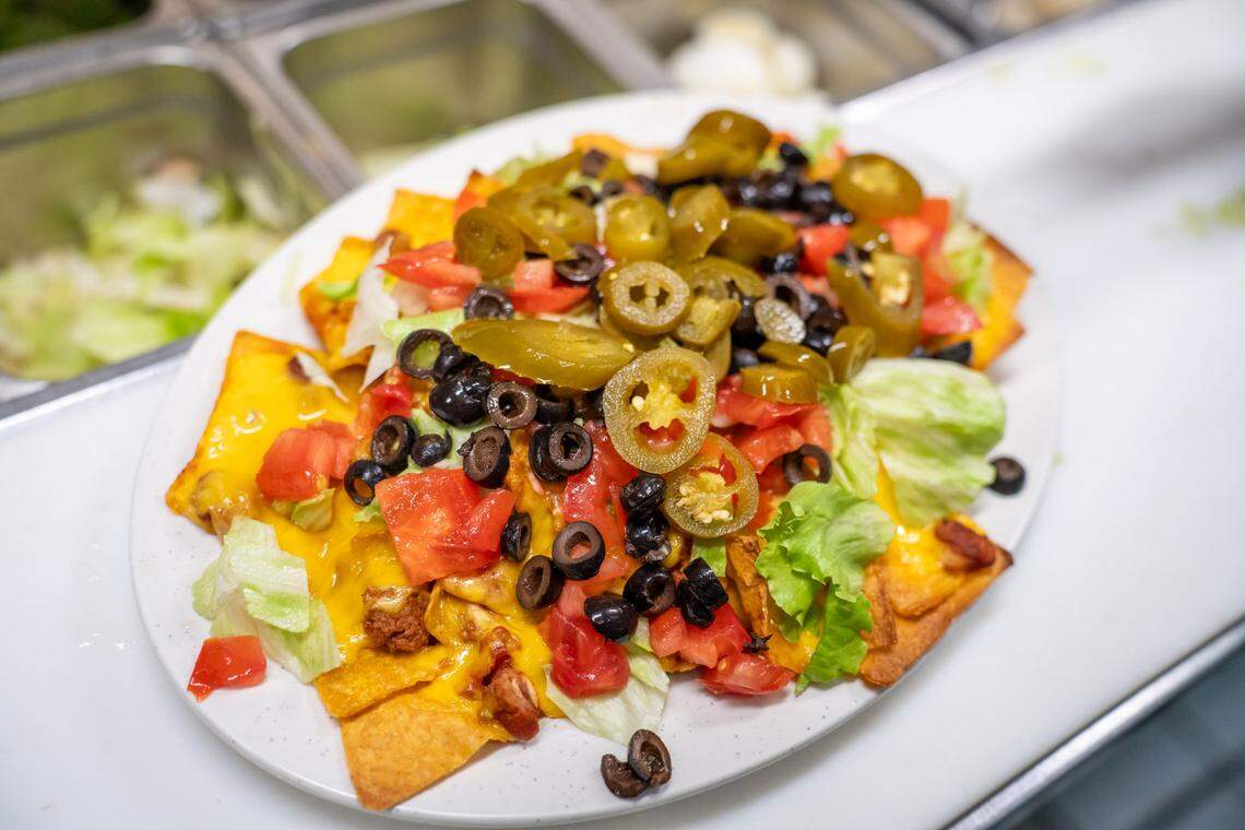 The Nachos Grande at Kristophers has tortilla chips topped with chili, cheddar, lettuce, tomato, jalapenos and black olives.