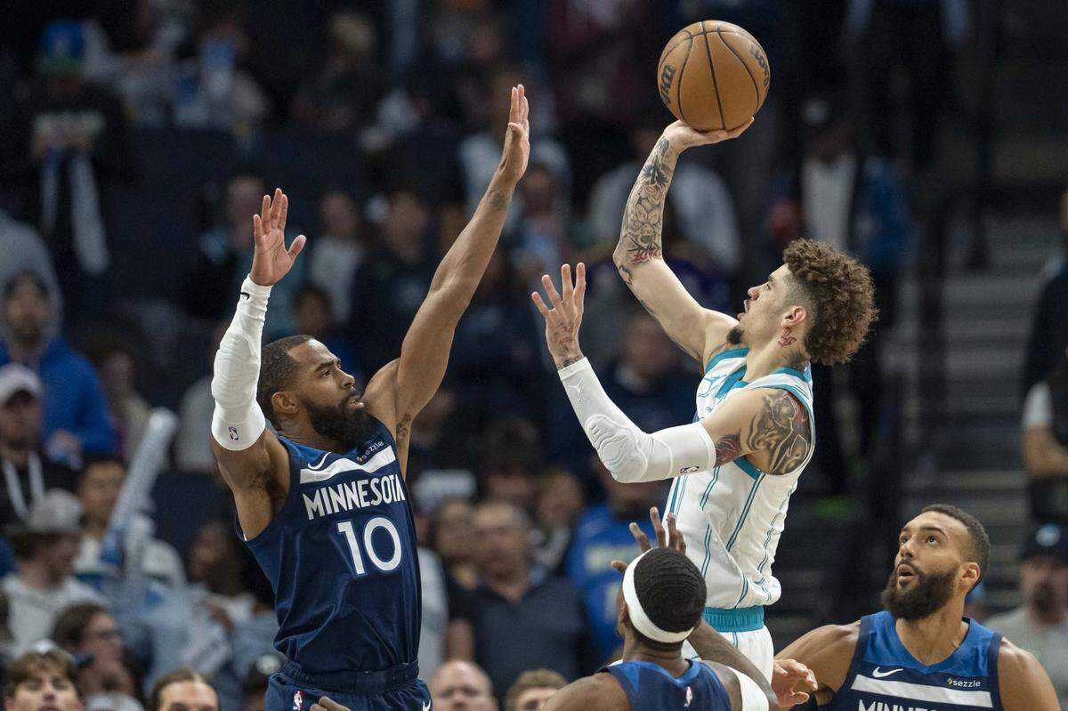 Charlotte Hornets guard LaMelo Ball (1) drives to the basket and shoots the ball over Minnesota Timberwolves guard Mike Conley (10) in the first half at Target Center.