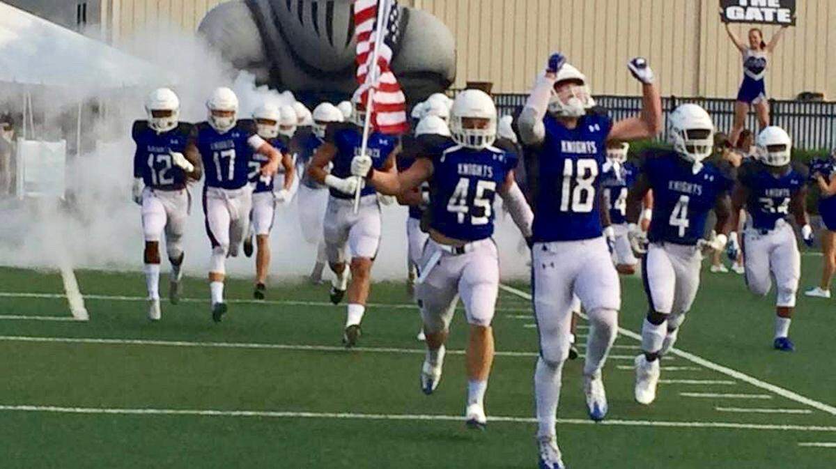 Charlotte Christian’s football team runs onto the field Friday before the Knights’ 6-0 upset win over N.C. 3A public school champion Charlotte Catholic