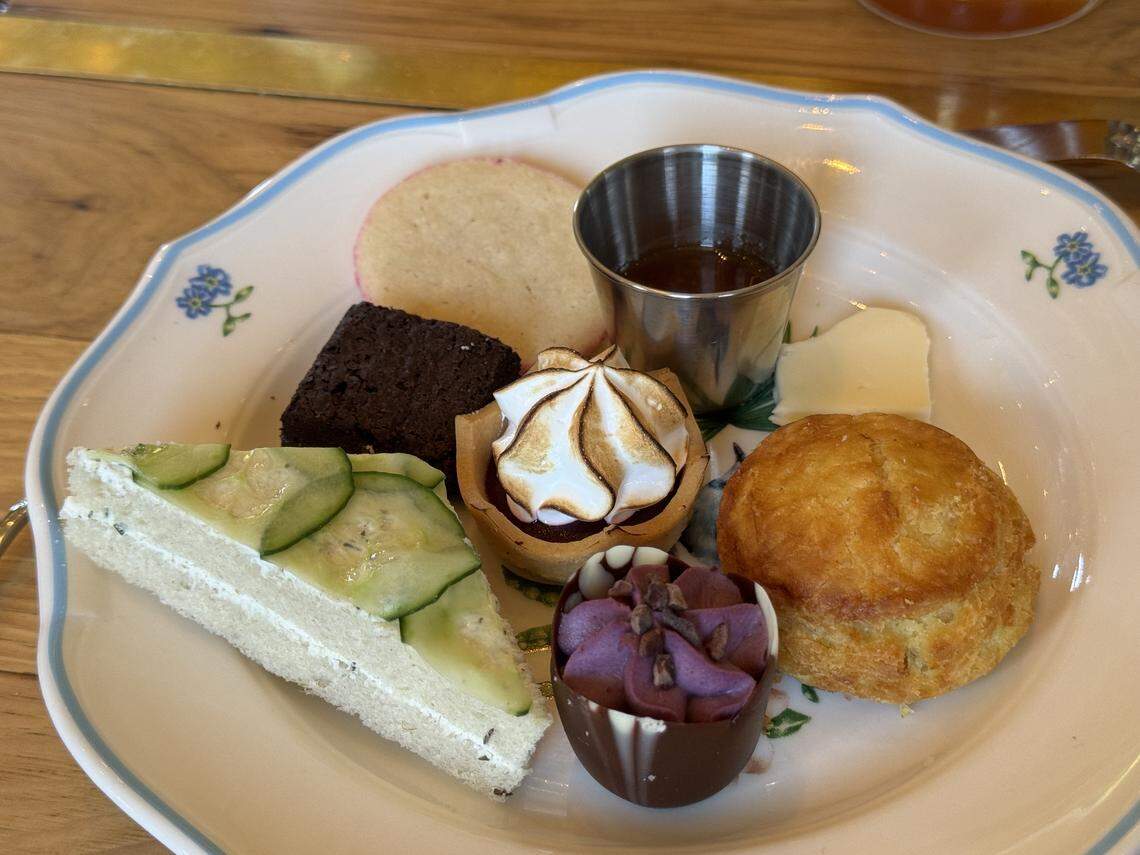 A colorful array of sweet and savory brunch items is served on a white scalloped plate with delicate blue floral patterns.