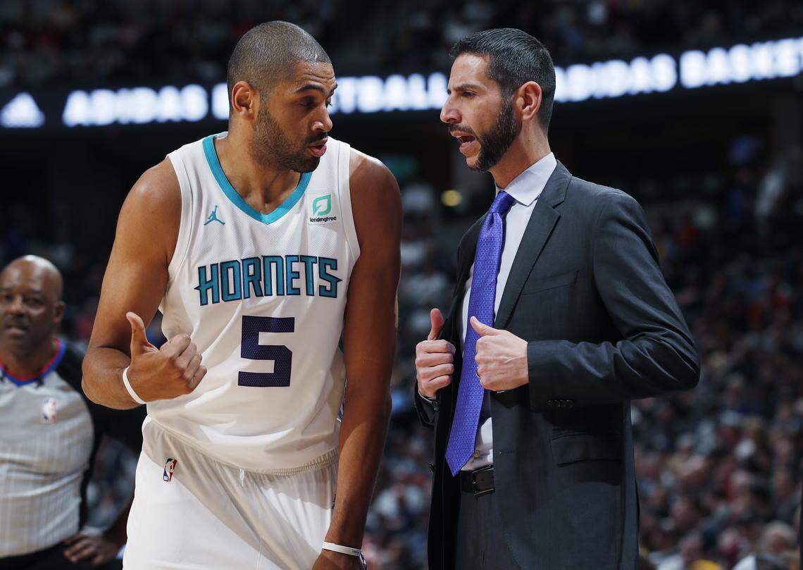 Charlotte Hornets forward Nicolas Batum, left, confers with head coach James Borrego in the first quarter of an NBA basketball game against the Denver Nuggets, Saturday, Jan. 5, 2019, in Denver. (AP Photo/David Zalubowski)