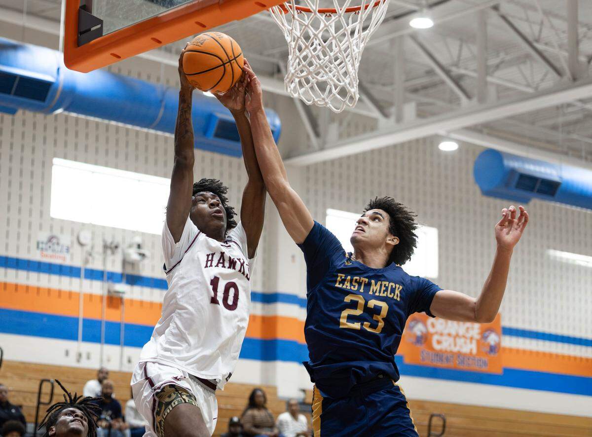 East Meck's Jordan Buzzard (23) blocks the shot of West Meck's Kamaree Graham (10) during late 2nd quarter action. West Meck Men's basketball team would take on East Meck at the Phenom Hoops Mike Gminski Classic at Marvin Ridge High School December 27, 2025.
