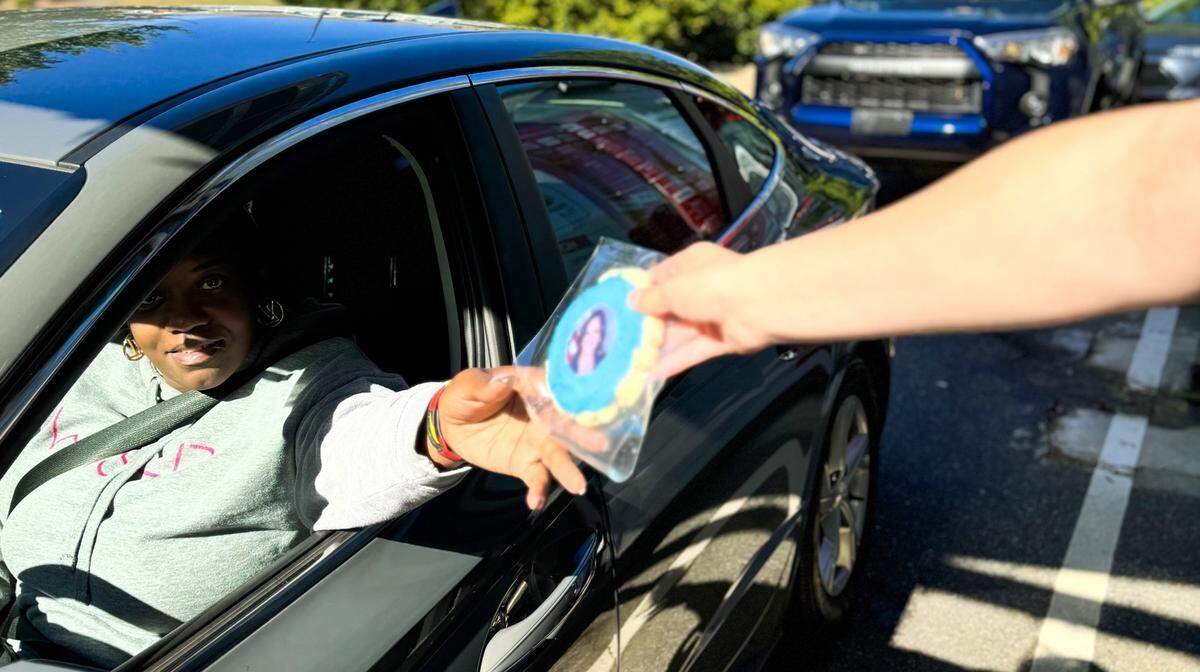 A Sip Co. customer selects a blue cookie with Vice President Kamala Harris.