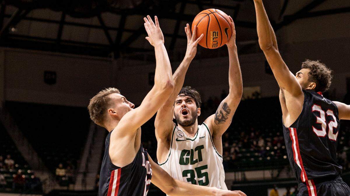 Charlotte’s Luka Vasic (35), center, drives to the basket as Davidson’s David Kristensen (12), left, and Nelson Boachie-Yiadom (32) during a season matchup at the Halton Arena on Tuesday, November 30, 2021.