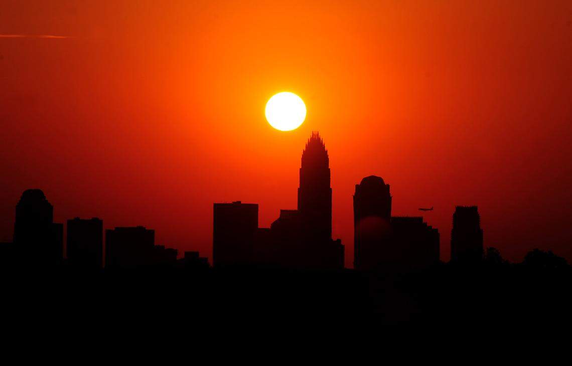 This file photo shows Charlotte’s skyline silhouetted against the sky as the sun sets on a hot June day. A warm air mass is forecast to push out the glorious false fall weather and send temperatures soaring, a National Weather Service meteorologist said on Saturday, Aug. 24, 2023.
