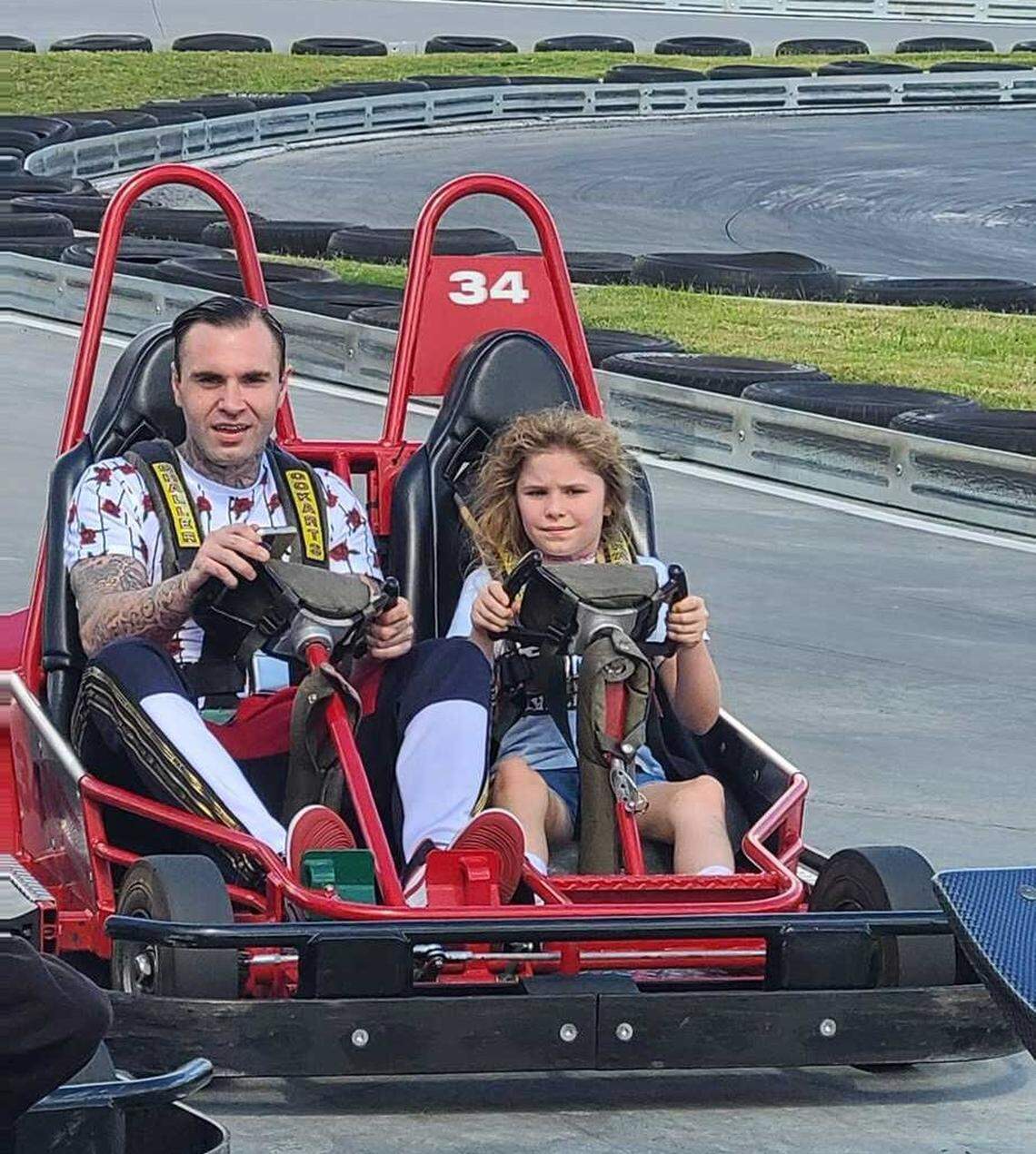 Brandon Combs rides around a Charlotte-area amusement park with his daughter, Allison, last summer. Combs was shot and killed by Concord police officers in February 2022 during a suspected theft at an auto dealership.