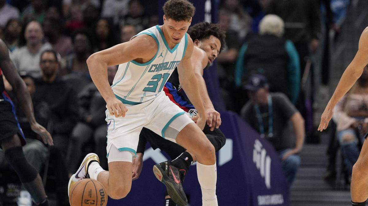 Charlotte Hornets forward Tidjane Salaun (31) tries for the loose ball from Detroit Pistons guard Cade Cunningham (2) during the first quarter at Spectrum Center.