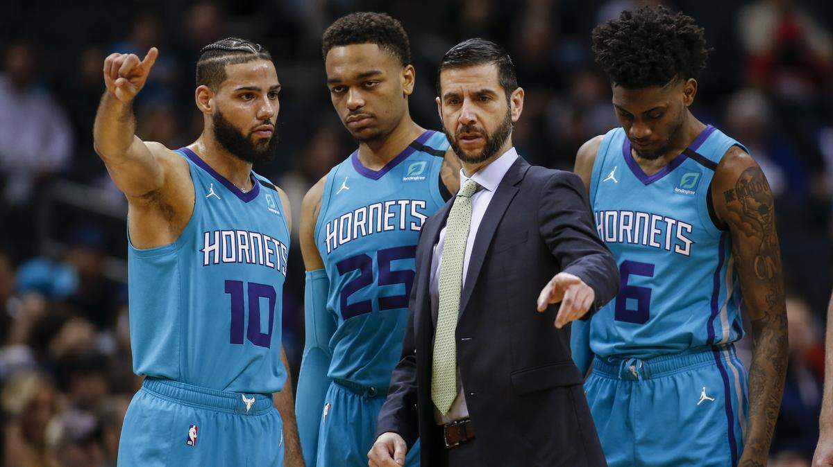 Charlotte Hornets coach James Borrego (center in tie) was frustrated with the referees in a double-overtime loss in Atlanta Monday, saying post-game that “every big call” went to Hawks’ way.