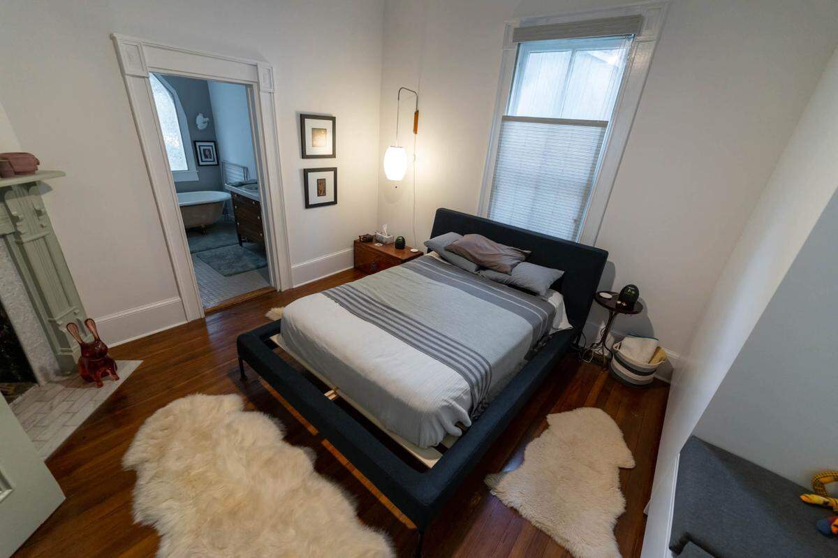 The master bedroom has a fireplace and a bathroom with a claw-foot tub. The owners had storage installed along the right side of the wall.
