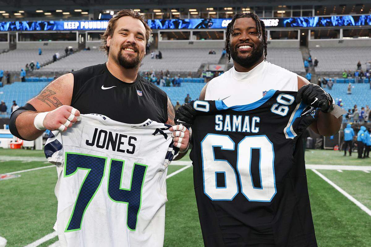 Carolina Panthers center Nick Samac, left, and Seattle Seahawks lineman Josh Jones exchange jerseys on Dec. 28, 2025, at Bank of America Stadium.