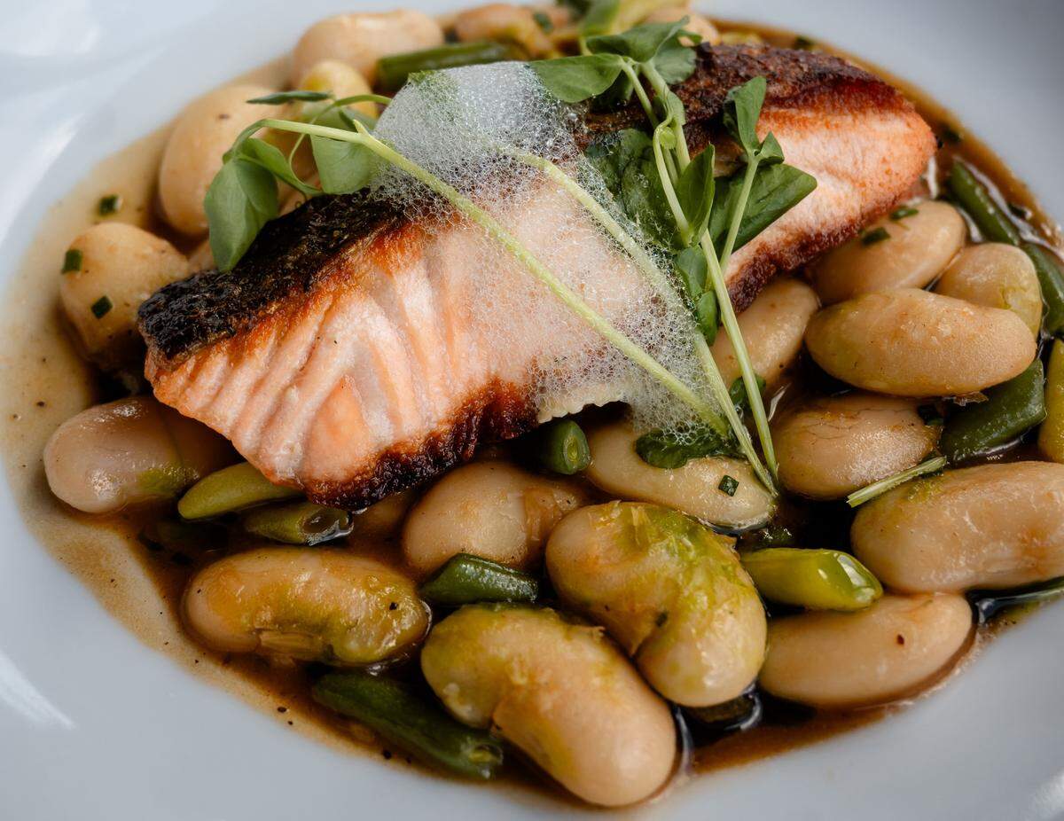 Pan-roasted salmon with winter bean cassoulet, Meyer lemon espuma and chervil oil at Napa.