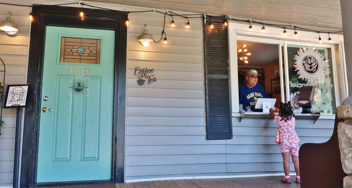 Backyard Brew co-owner TK Khalil takes an order at the coffee shop on East Boulevard.