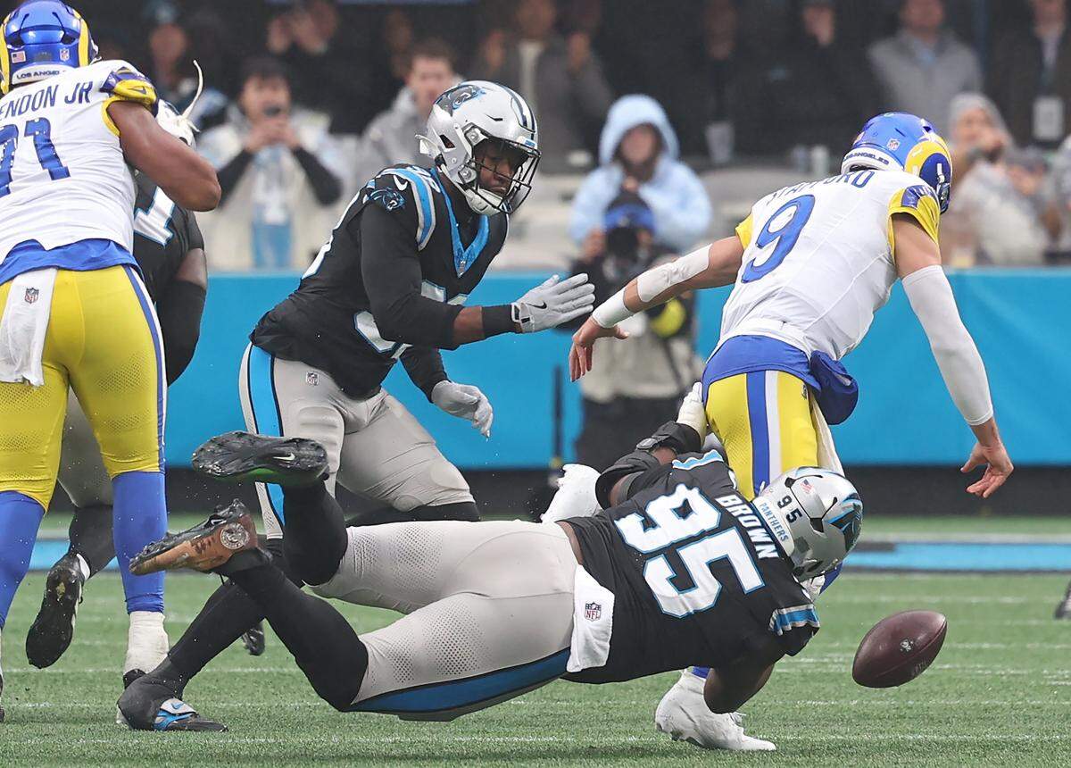 Carolina Panthers defensive tackle Derrick Brown, left/center, forces Los Angeles Rams quarterback Matthew Stafford, right, to fumble the ball during action at Bank of America Stadium in Charlotte, NC on Sunday, November 30, 2025. Panthers linebacker D.J. Wonnum recovered the ball. The Panthers defeated the Rams 31-28.