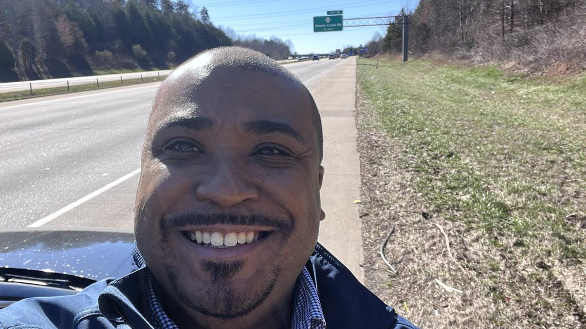 Rep. Terry Brown Jr. stands on Interstate 485 in front of the Exit 4 sign which now reads “Steele Creek” instead of “Fort Mill.”