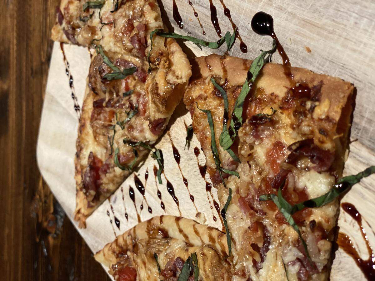 Belmont Cocktail Club’s Prosciutto Pizzette has caramelized onion crema, prosciutto, roasted tomatoes and fresh basil.
