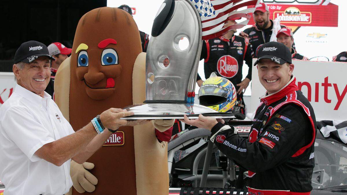Johnsonville's Ralph Stayer, left, holds the trophy with winning driver Michael McDowell at the NASCAR Xfinity Road America race in August 2016 at Elkhart Lake's Road America in Elkhart Lake, Wisconsin. On Sunday, McDowell started 26th and finished 21st at the Overton's 400 at Chicagoland Speedway.