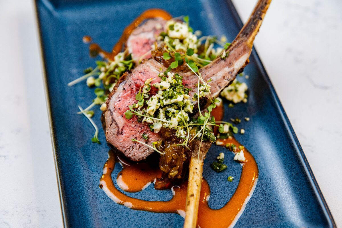 Lamb Lollipops: Marinated lamb chops, goat cheese gremolata, shallot jam, piquillo vinaigrette at Rosemont Market & Wine Bar.