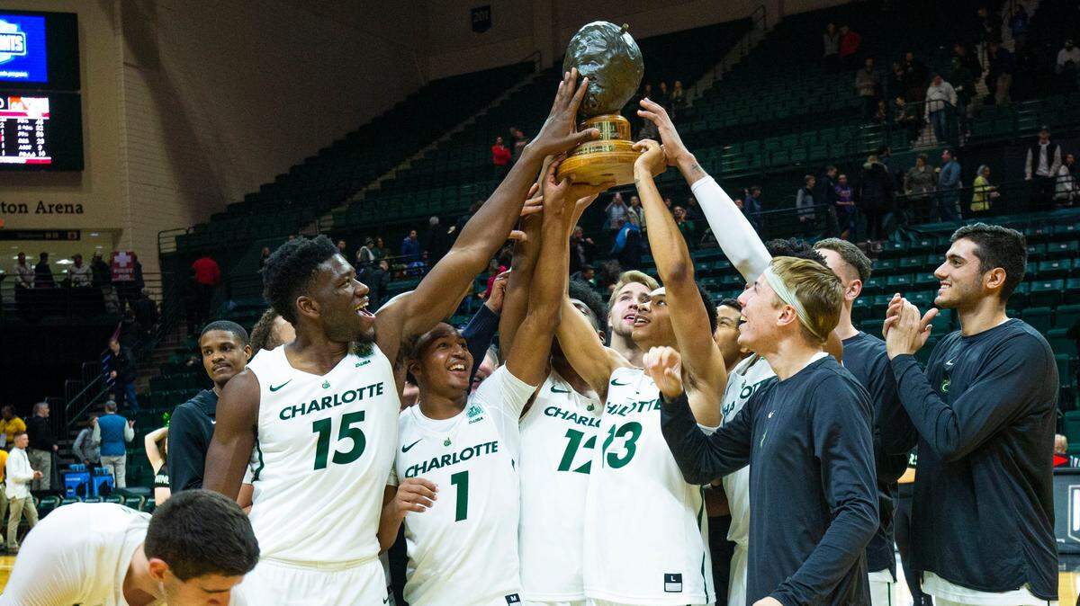 The Charlotte 49ers hold up the “Battle for the Hornets’ Nest” trophy after beating Davidson 71-58 last season at Halton Arena.