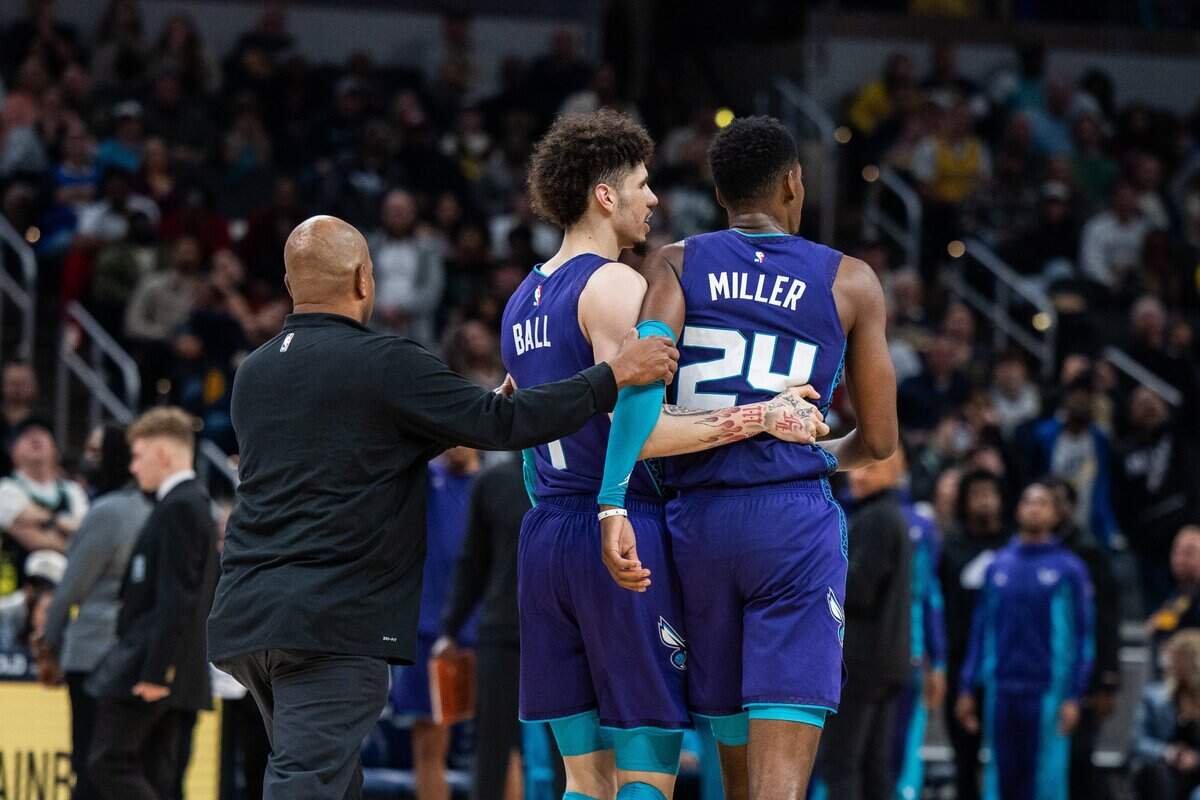 Charlotte Hornets guard LaMelo Ball (1) pulls forward Brandon Miller (24)  away from the crowd in the second half against the Indiana Pacers at Gainbridge Fieldhouse. 