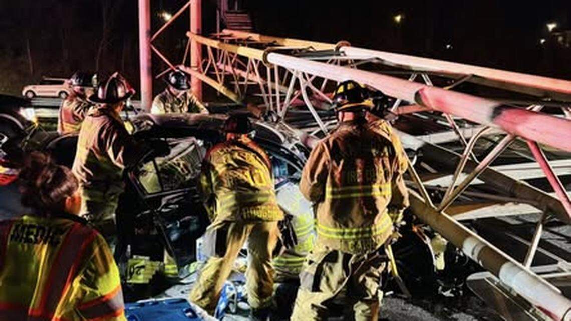 Firefighters work to free a driver after an overhead sign collapsed onto a car on Interstate 77 South in Charlotte late Friday, Nov. 28, 2025.