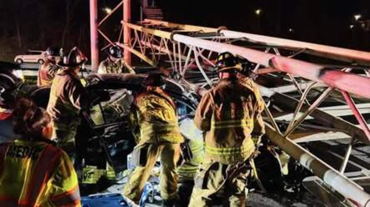 Firefighters work to free a driver after an overhead sign collapsed onto a car on Interstate 77 South in Charlotte late Friday, Nov. 28, 2025.