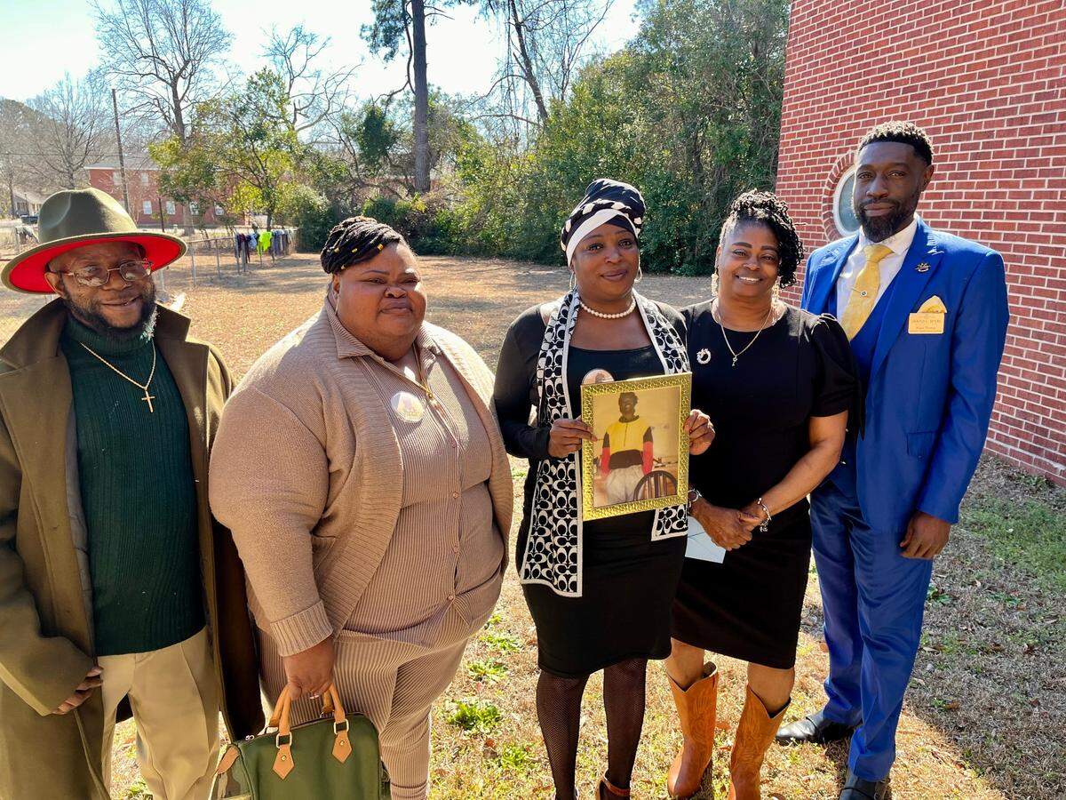 Abdul Wright’s family poses with a photo of him after his funeral on Feb. 22. From left: Sharonda Gabriel, Shondell Wright, Samella Wright and Nigel Thomas.