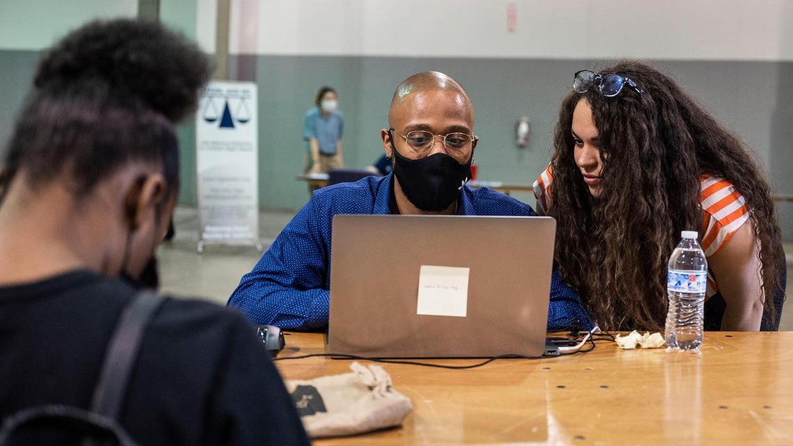 Devon Allen, center, and Mirakle Hensen, right, work together to help a woman with a rent relief application at the Park Expo on Oct. 1, 2021 in Charlotte. DreamKey Partners is planning for the future of the rent relief program after federal funding ends.
