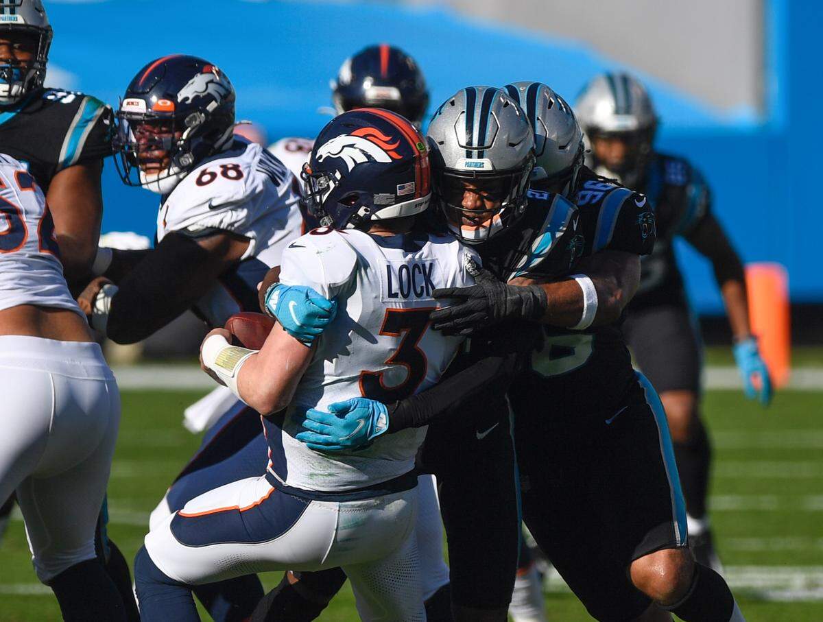 Denver Broncos quarterback Drew Lock is sacked by Carolina Panthers’ Jeremy Chinn (21) forcing a fumble recovered by Carolina’s Efe Obada during the second quarter of their game Sunday, December 13, 2020.