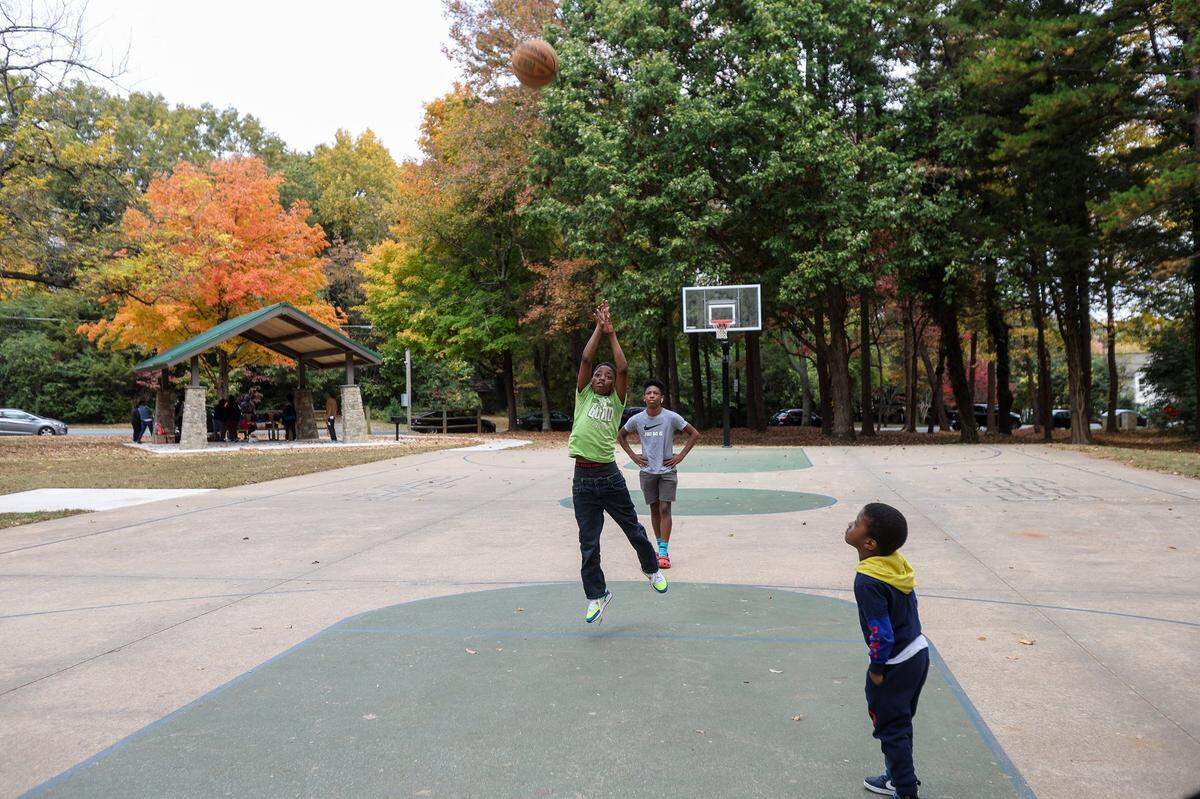 Children play basketball in Tom Hunter Neighborhood Park on Saturday, October 29, 2022. The park received a grant in 2022 for renovations that included new walking trails, benches and a pavilion. The park, once deemed a dangerous area, is now frequently visited by families for the playground, basketball court and green space.