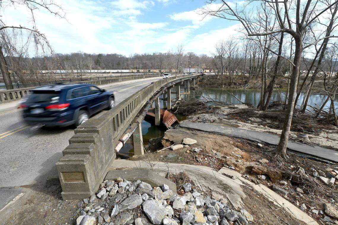 Traffic passes over the French Broad River in Asheville, NC on Wednesday, February 5, 2025. Debris and the destroyed shoreline are still visible following Hurricane Helene in late September 2024.