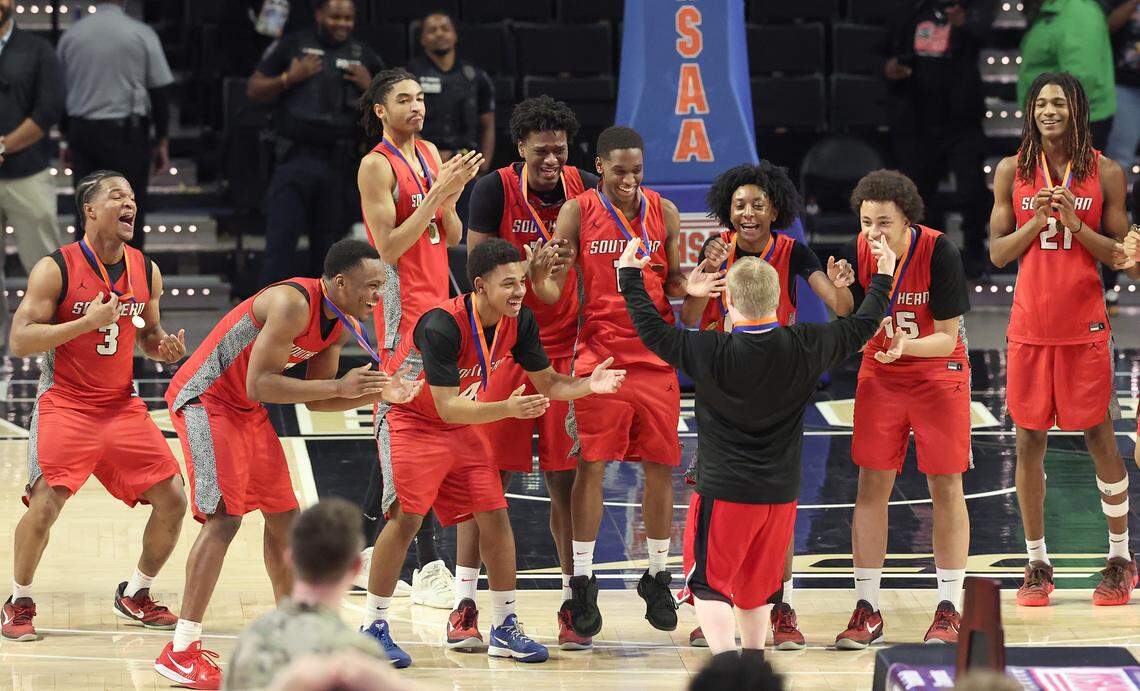 Members of the Southern Durham basketball team react as one of the team’s personnel receives his championship medal following the team’s 54-47 win over Mooresville in the 7A boys’ championship game on Saturday at Lawrence Joel Veterans Memorial Coliseum in Winston-Salem.