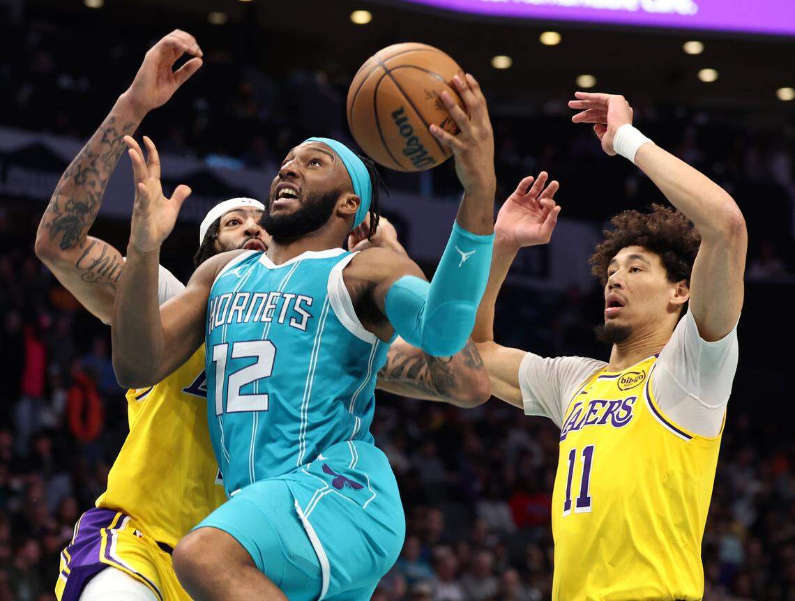Charlotte Hornets guard Josh Okogie, center, drives to the basket past Los Angeles Lakers center Anthony Davis, left and forward Jaxson Hayes, right, during action at Spectrum Center in Charlotte, NC on Monday, January 27, 2025. The Lakers defeated the Hornets 112-107.