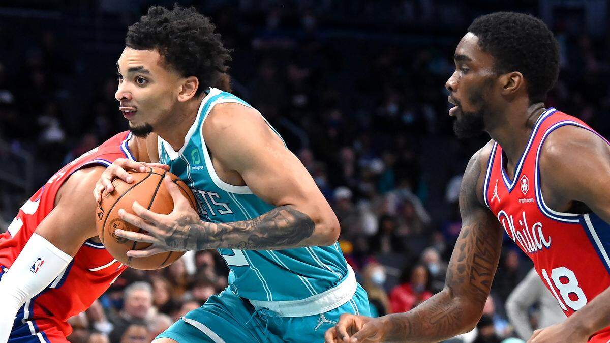 Charlotte Hornets guard James Bouknight, center, splits the Philadelphia 76ers defense on a drive to the basket during first quarter action on Wednesday, December 8, 2021 at Spectrum Center in Charlotte, NC.
