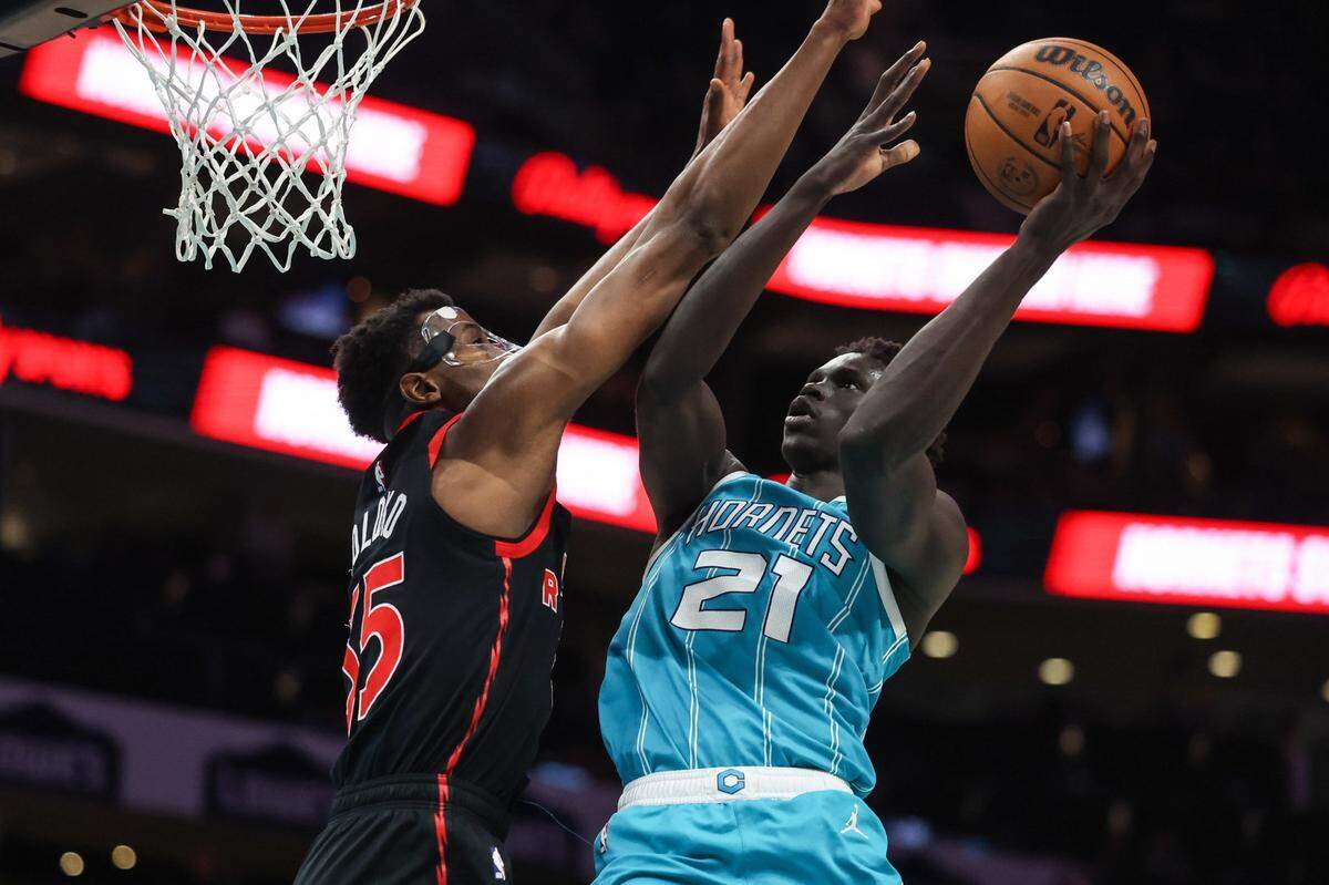 Hornets forward JT Thor, right, shoots over Raptors center Christian Koloko during the game at Spectrum Center on Tuesday, April 4, 2023.