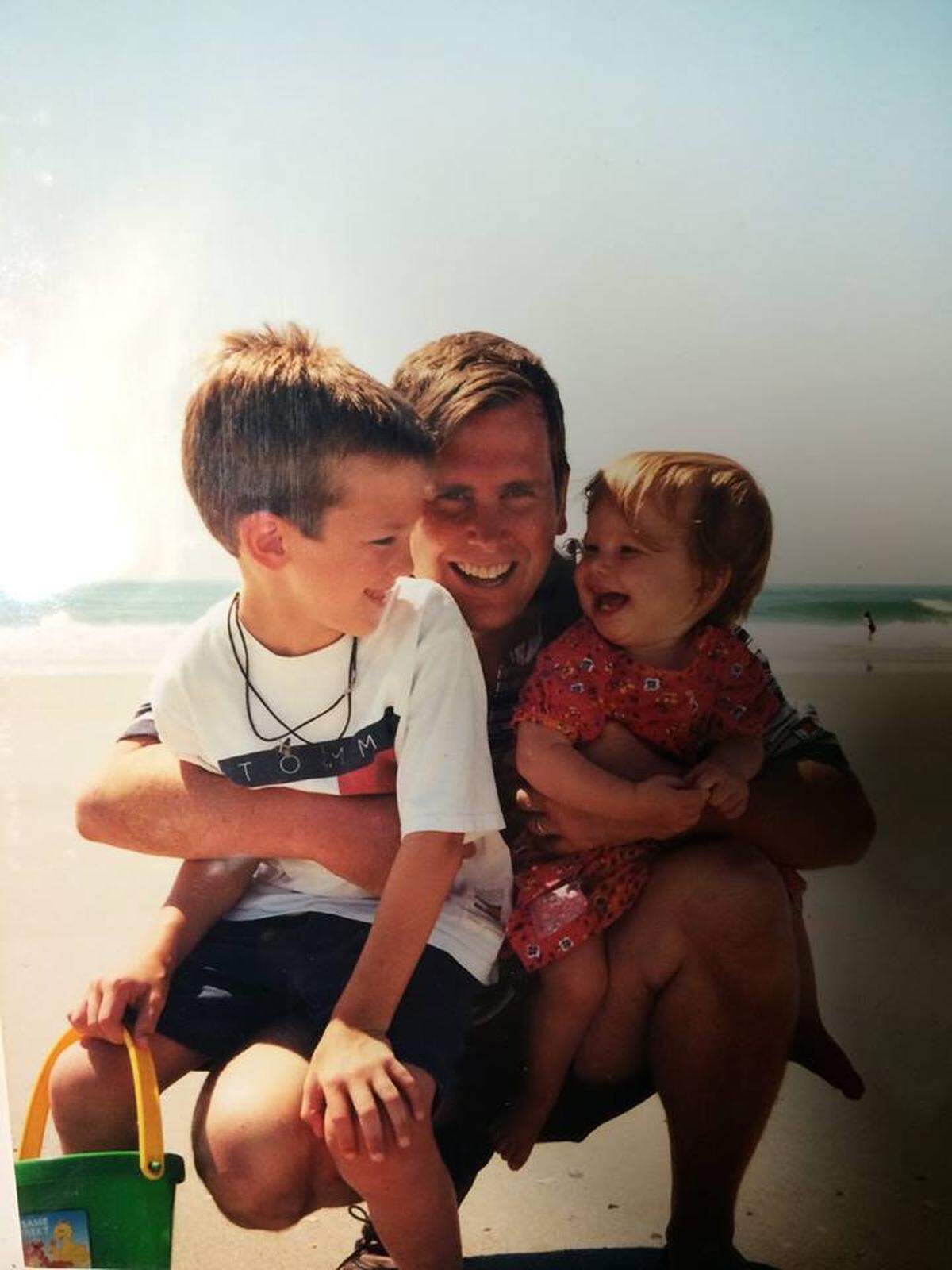Mark Burud makes 18-month-old Grace and his son Alec laugh at Topsail Beach on family vacation.