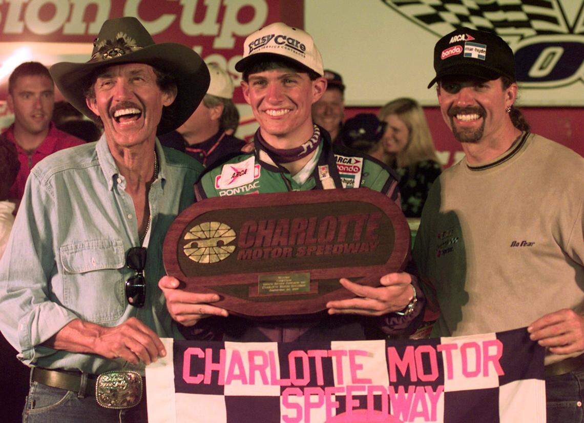 09/29/98: Adam Petty (center) celebrates in victory circle after winning the Easy Care 100 race at the Charlotte Motor Speedway with his grandfather “The King” Richard Petty (left) and father Kyle Petty.