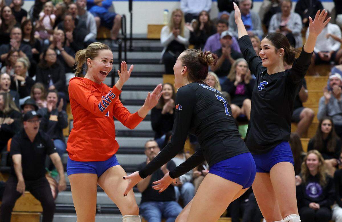 Marvin Ridge High girls volleyball players Isabella Perkins, left, Kiley Petras, center and Karen Baylog, right, celebrate a point against Northern Guilford during NC 4A quarterfinal volleyball playoff action at Marvin Ridge High School on Tuesday, October 29, 2024. Marvin Ridge defeated Northern Guilford 3-0.