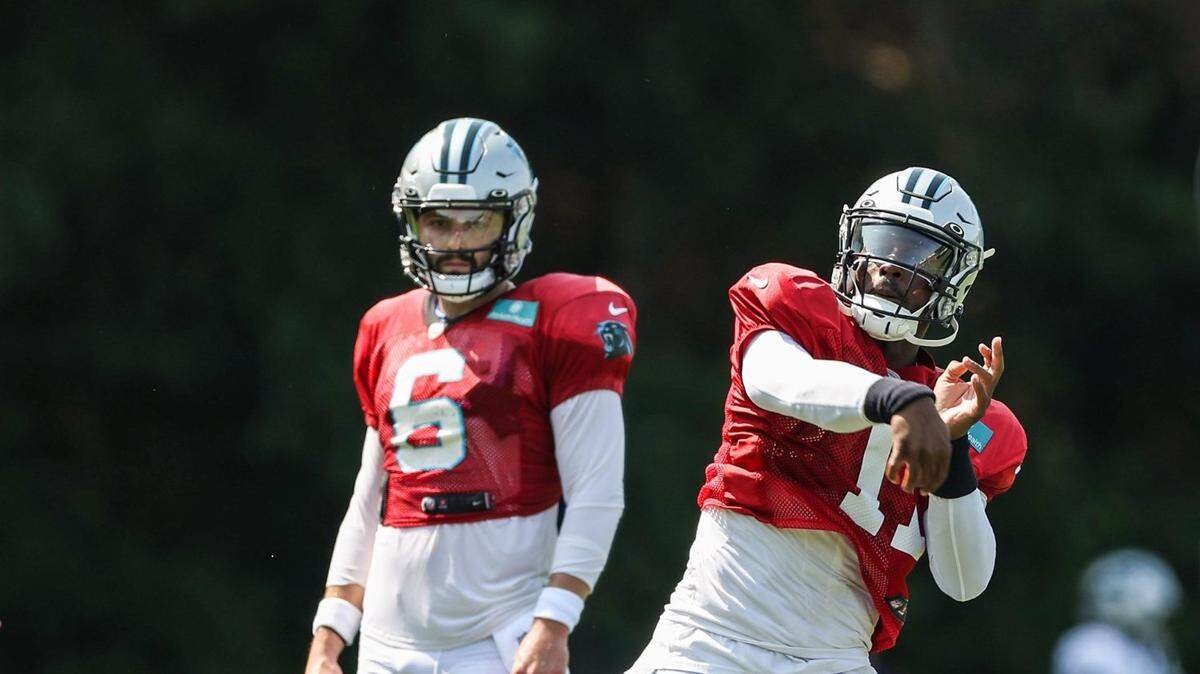 Panthers quarterback PJ Walker, right, throws a pass as fellow quarterback Baker Mayfield watches during practice at Training Camp on Tuesday, August 2, 2022 in Spartanburg, SC.