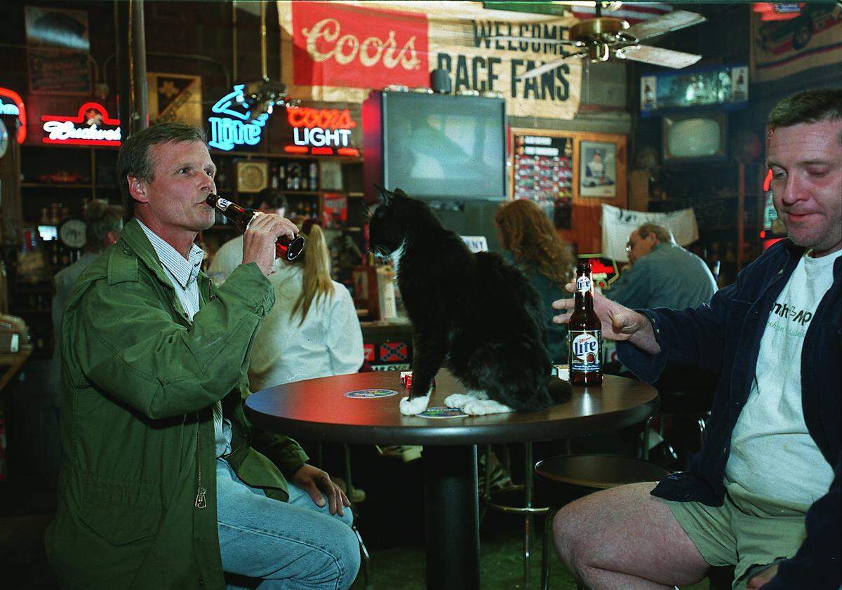 In this 2001 file photo, regulars at Puckett’s Farm Equipment socialize and make room for owner Gary Puckett’s cat, Blackie. Puckett is planning to close the business next March.