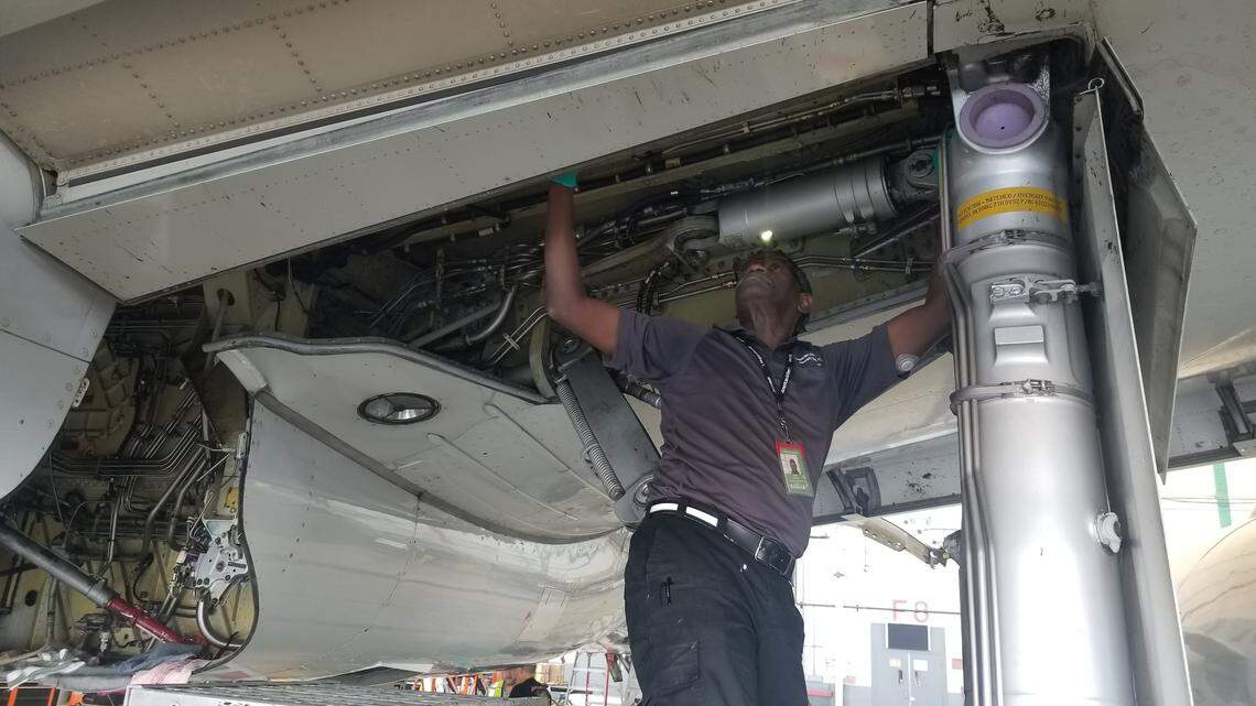 Imad Hassan, an aircraft maintenance technician, works on an American Airlines aircraft near Charlotte Douglas International Airport Monday. The company is adding new maintenance jobs in Charlotte.