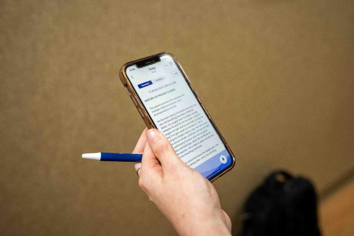 Dr. Paige Driver reviews patient notes taken by DAX Copilot, the AI-driven application on her phone that records patient-doctor interactions.