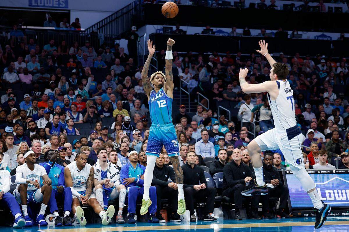 Charlotte Hornets guard Kelly Oubre Jr. (12) shoots over Dallas Mavericks guard Luka Doncic (77) during a game at Spectrum Center in Charlotte, N.C., Saturday, March 19, 2022. Charlotte beat Dallas 129-108.