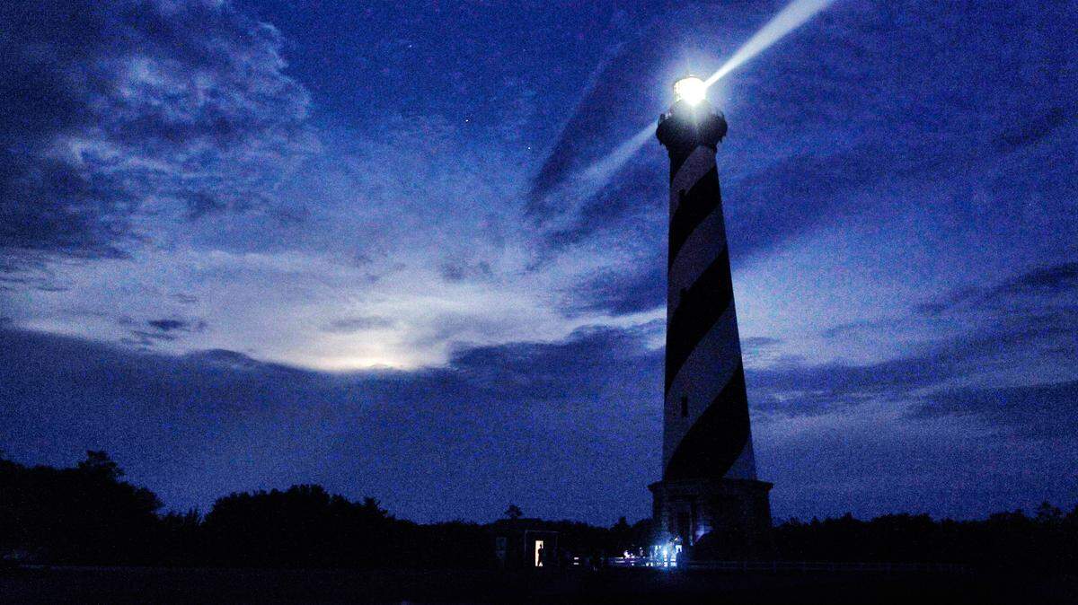 The “super moon” struggles to break through the cloud cover behind the Cape Hatteras lighthouse.