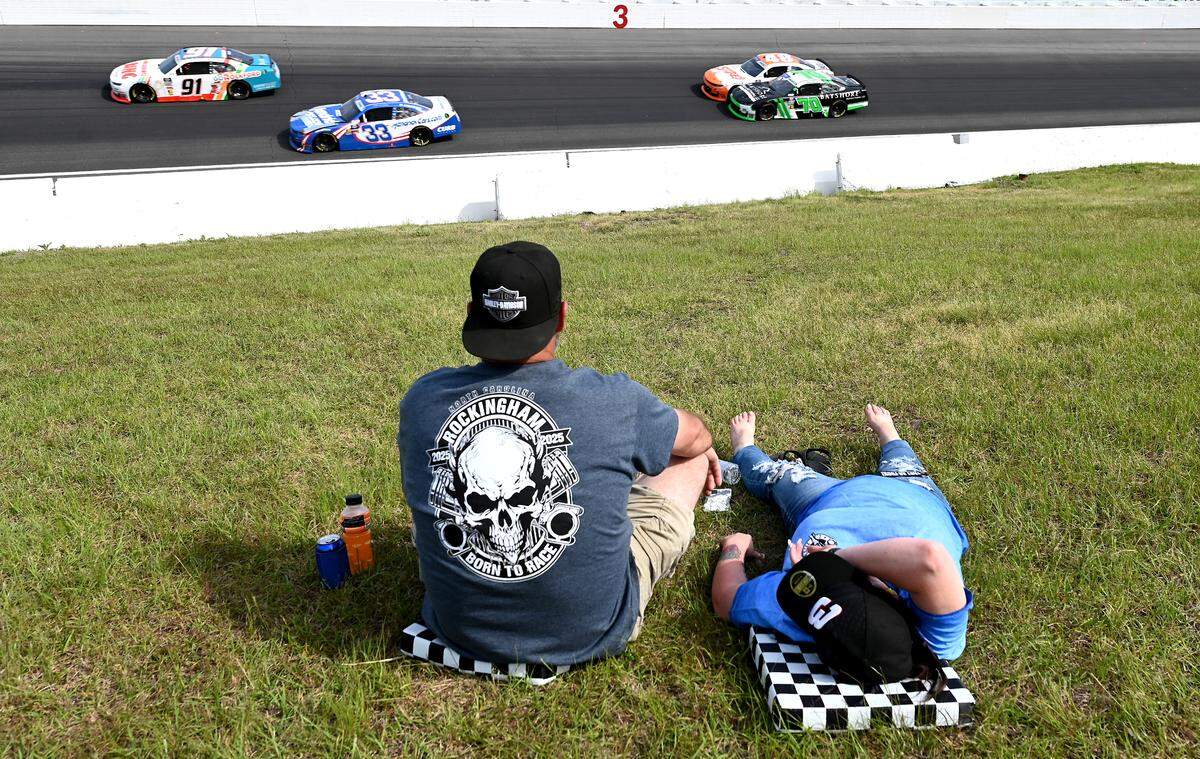 NASCAR fans enjoy the Xfinity Series race from a grassy area in Turn 3 during the North Carolina Education Lottery 250 at Rockingham Speedway on Saturday, April 19, 2025.