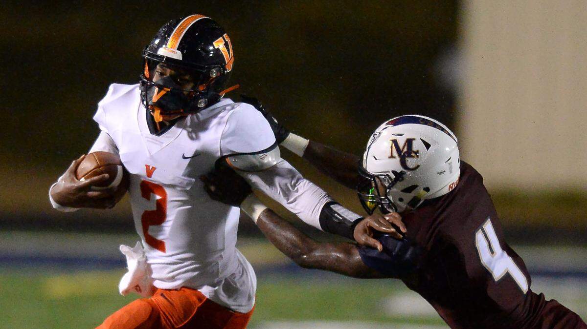 Vance Cougars quarterback Austin Grier (left) breaks to the outside in his team’s 27-7 win over Mallard Creek Friday night in the high school football season opener for both teams.