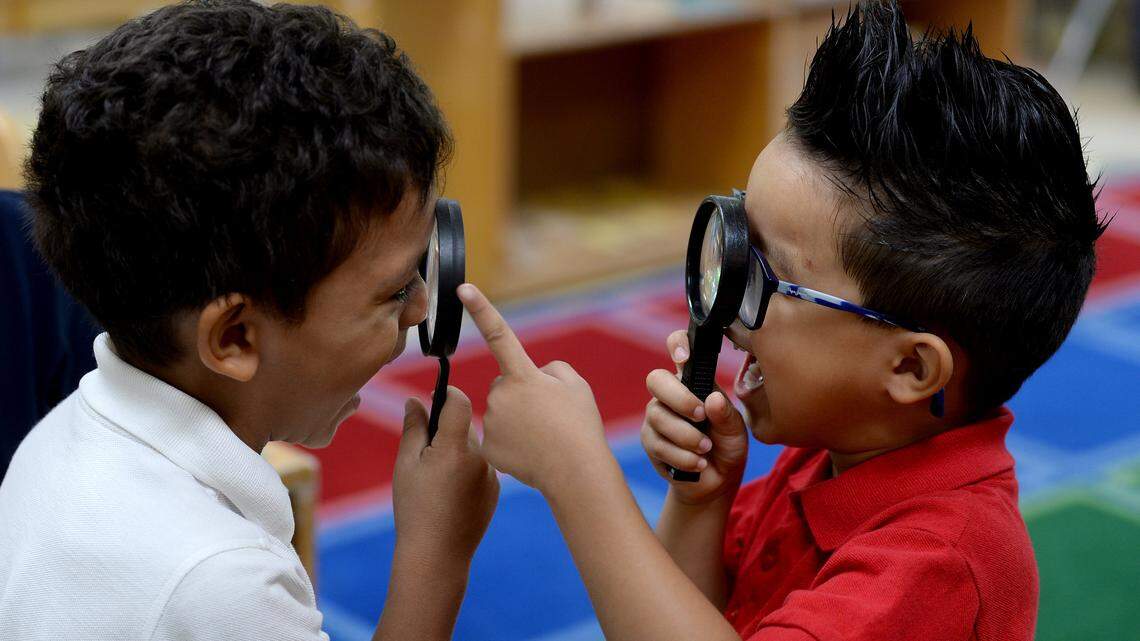 In this 2019 photo, Ronis Canaca, left, and Hector Vasquez Gomez check out each other through magnifying glasses as they use the glasses during an exercise in a Pre-K class at Smart Kids No. 1 in Charlotte.